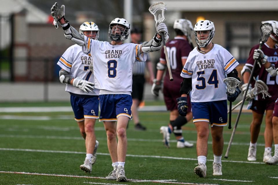 Grand Ledge's Tieson Cooper, center, celebrates a goal against Okemos during the fourth quarter on Tuesday, May 10, 2022, at Grand Ledge High School.