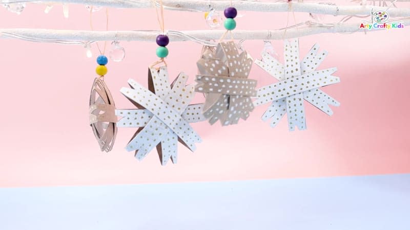 Snowflake ornaments made with slices of cardboard paper towel tubes