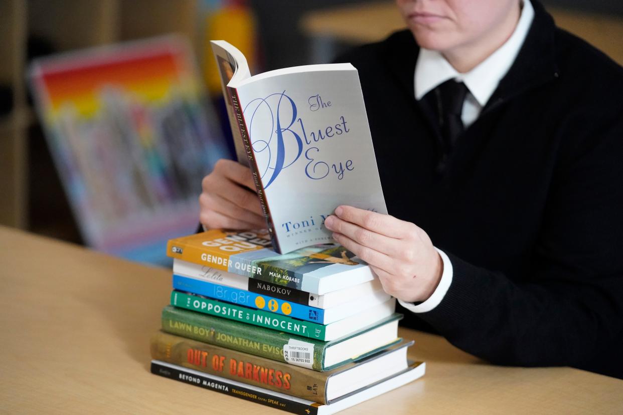 In this Dec. 16, 2021, file photo, Amanda Darrow, director of youth, family and education programs at the Utah Pride Center, poses with books, including 