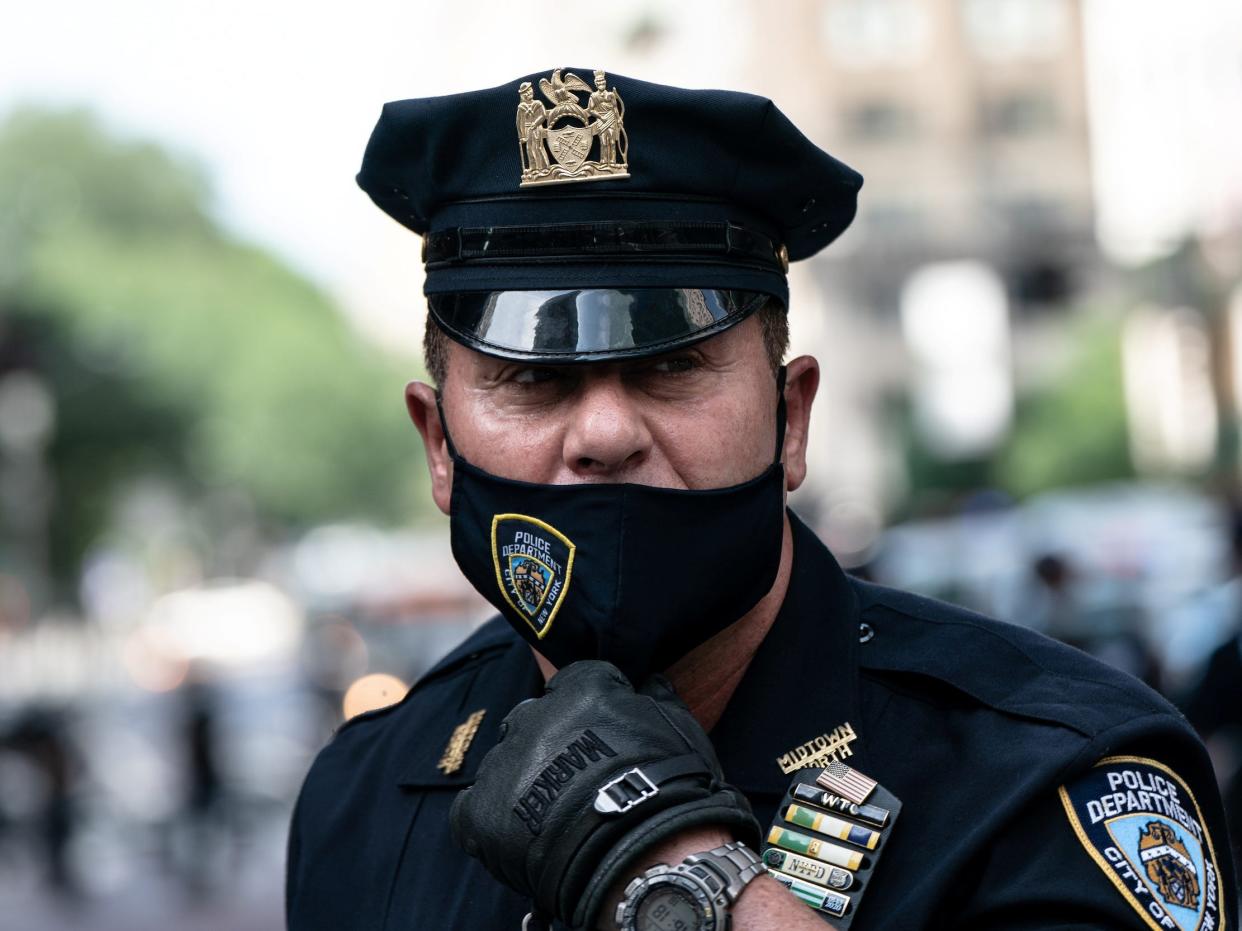 A NYPD officer wearing a protective mask stands guard outside Trump Tower while demonstrators take part in a protest against racial inequality in the aftermath of the death in Minneapolis police custody of George Floyd, in New York City, New York, U.S., July 5, 2020.