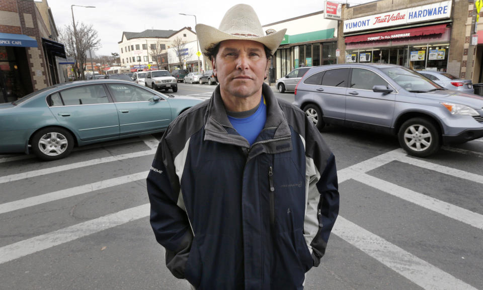 In this Tuesday, March 25, 2014 photo, Carlos Arredondo stands in the Jamaica Plain neighborhood of Boston. Arredondo, along with volunteer Devin Wang and EMT Paul Mitchell, are credited with helping to save the life of Jeff Bauman, who suffered traumatic injuries in the Boston Marathon bombings. (AP Photo/Charles Krupa)