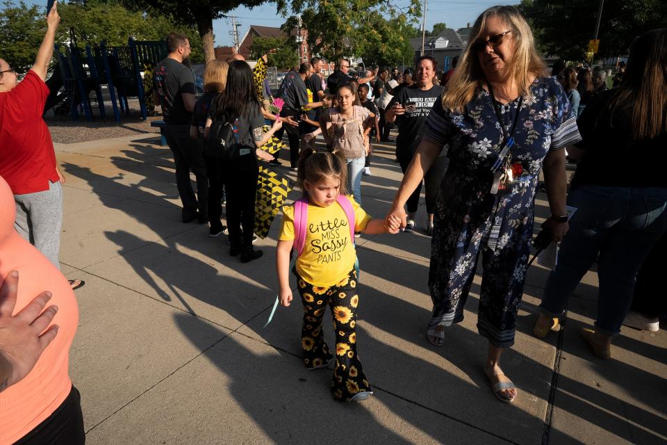 Sara Rannebarger, 6, wearing her "Miss Sassy Pants" shirt, cries a bit as she walking into Columbus City Schools' Avondale Elementary School with Principal April Knight on Wednesday, Aug. 23, 2023 during a "Clap-in" on the district's first day of school for all students. The event featured mascots from the Columbus Crew and the Columbus Blue Jackets.