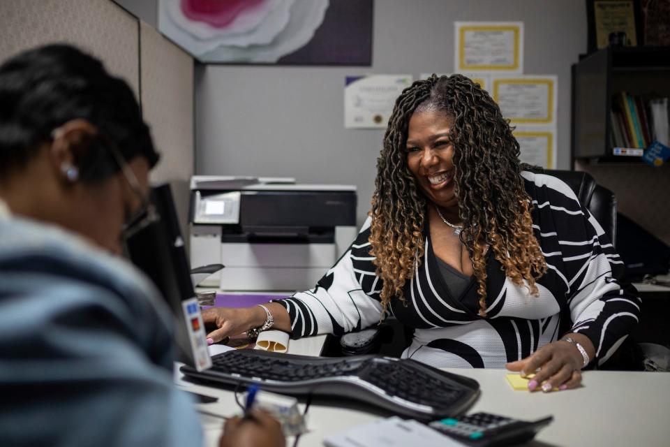 Iesha Morgan, a tax preparer and owner of Tax Stars LLC, smiles as she helps Tiffany Wade inside her office at the Green Medical Supply LLC in Dearborn on Wednesday, March 20, 2024. Morgan has been assisting Wade with her taxes for six years.