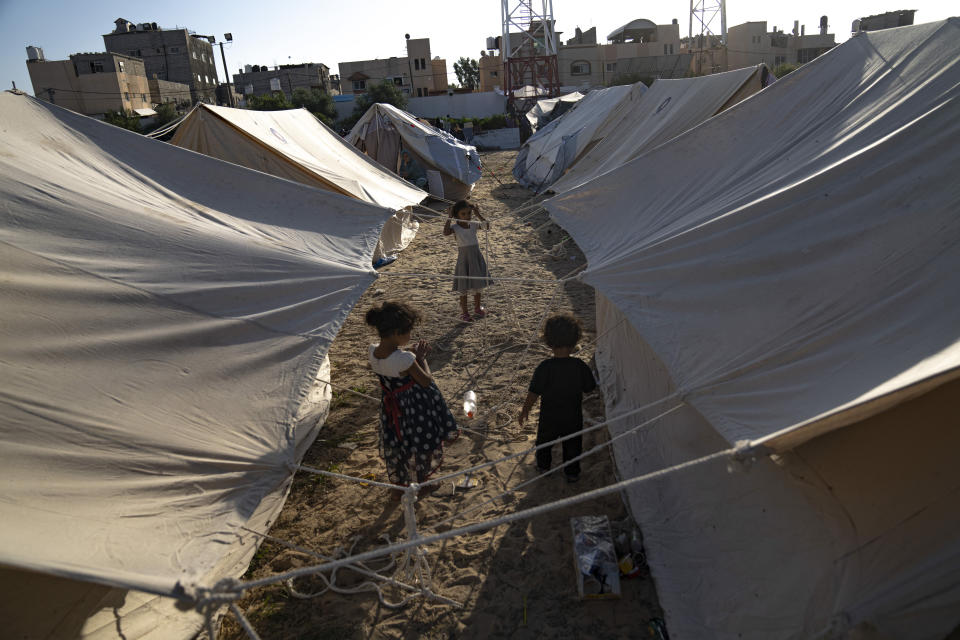 Palestinian children displaced by the Israeli bombardment of the Gaza Strip walk in a UNDP-provided tent camp in Khan Younis on Thursday, Oct. 19, 2023. (AP Photo/Fatima Shbair)