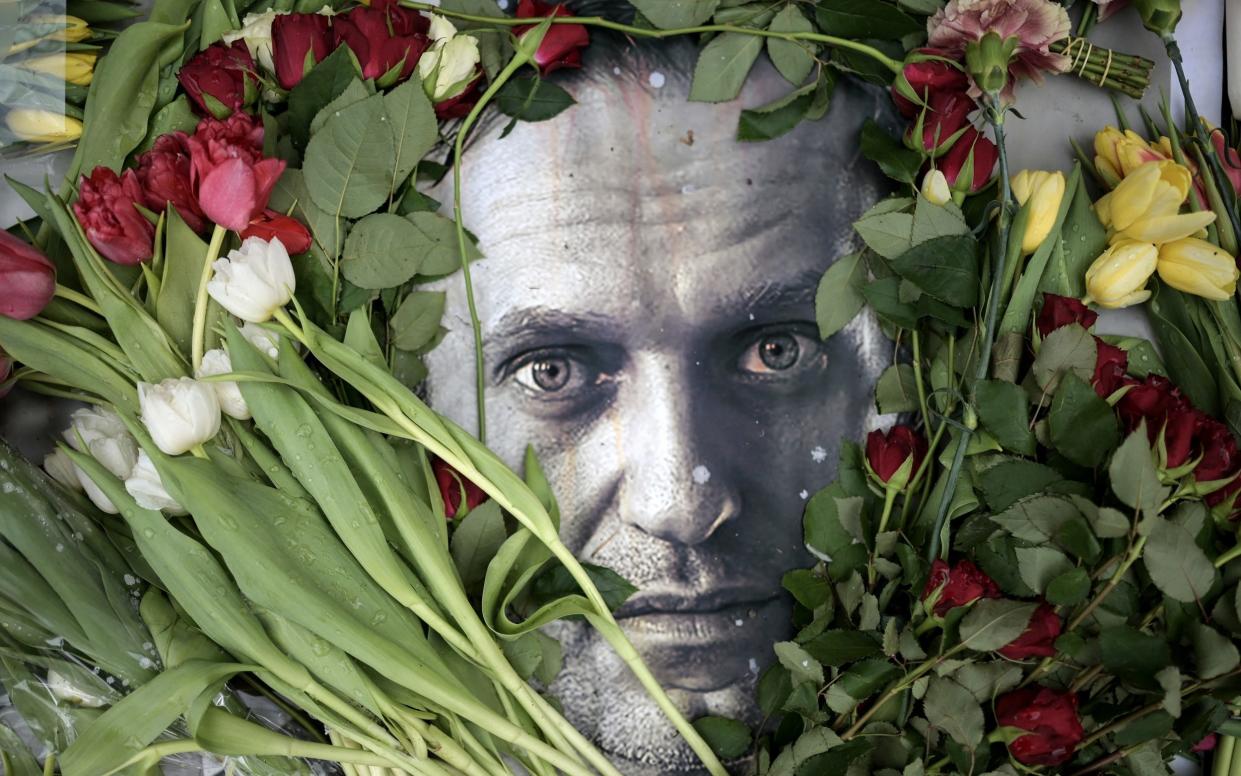 Flowers are seen placed around a portrait of Alexei Navalny at a makeshift memorial in front of the former Russian consulate in Frankfurt am Main, western Germany