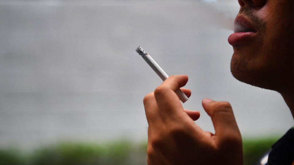 A man smokes a cigarette. A Cornwall company is rewarding non-smoking staff with four days extra of holidays.