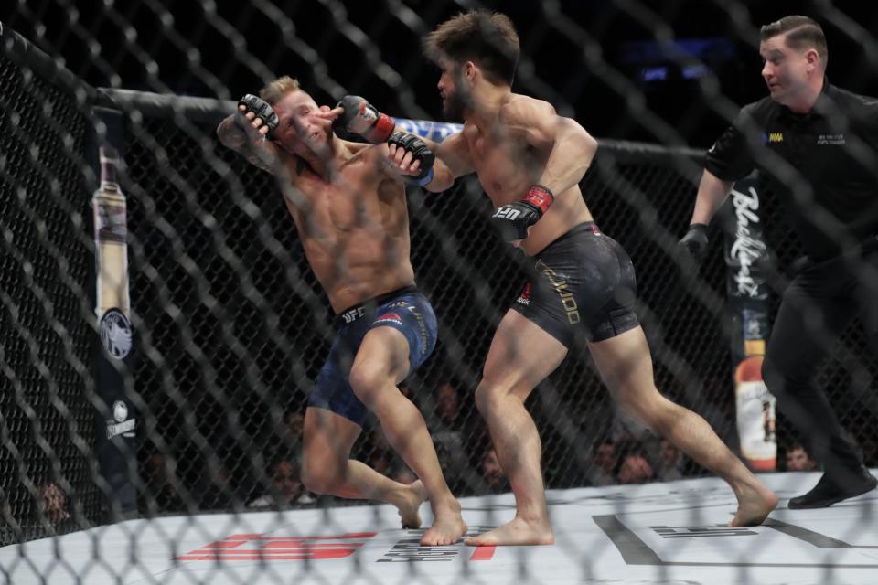 Henry Cejudo, right, knocks down TJ Dillashaw during the first round of a flyweight mixed martial arts championship bout at UFC Fight Night Sunday, Jan. 20, 2019, in New York. Cejudo stopped Dillashaw in the first round. (AP Photo/Frank Franklin II)