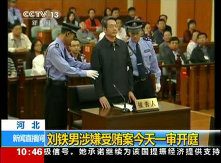 Former deputy head of China's top planning agency, The National Development and Reform Commission, Liu Tienan is escorted by police as he arrives for his trial at the Intermediate People's Court in Langfang, Hebei province, in this still image taken from video shot on September 24, 2014. REUTERS/CCTV via Reuters TV