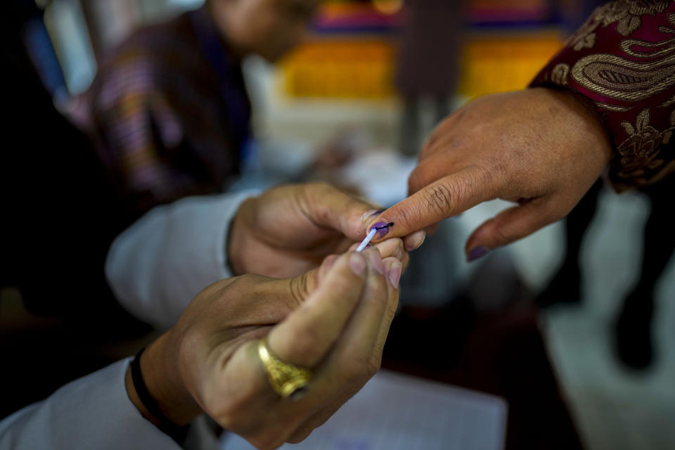 A polling official puts ink mark on the index finger of a voter before she cast her vote in the national elections in Deothang, Bhutan, Tuesday, Jan. 9, 2024. The landlocked country in the eastern Himalayan mountain range is electing a new Parliament, with the parties in contest promising to fix the nation’s economic crisis. (AP Photo/Anupam Nath)