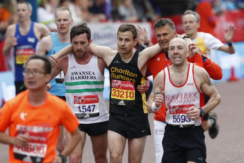 Good Samaritan: Matthew Rees helps David Wyeth over the finish line (AFP/Getty Images)