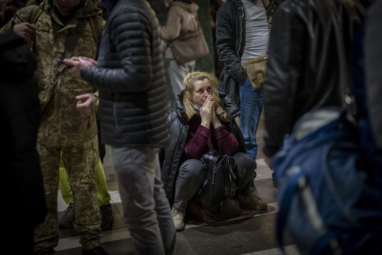 A woman reacts as she waits for a train trying to leave Kyiv, Ukraine, Feb. 24, 2022.