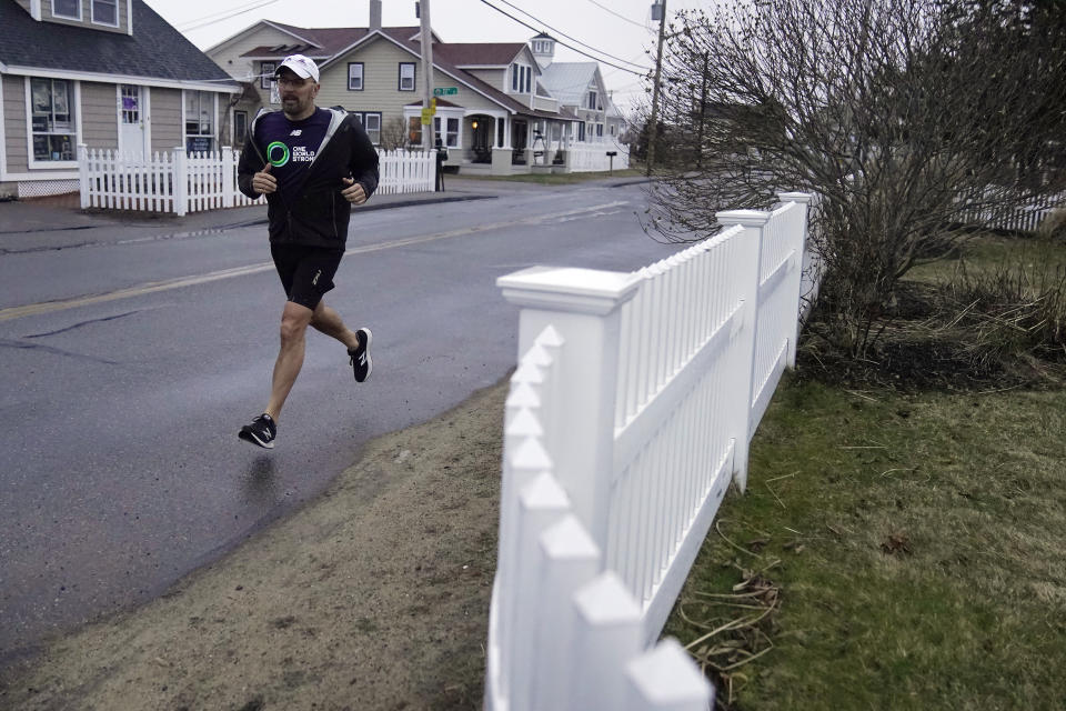 Dave Fortier, of Newburyport, Mass., president of One World Strong Foundation, trains for the 2023 Boston Marathon as he runs along a street Tuesday, April 4, 2023, in Newburyport. Fortier was hit in the foot by shrapnel in the 2013 bombing and doesn't remember finishing the race. (AP Photo/Steven Senne)