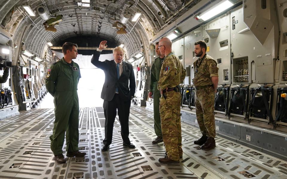 Boris Johnson speaks to Air Loadmaster 99 Squadron Sergeant Tom Clare, Officer Commanding 99 Squadron Wing Commander Will Essex and Officer Commanding Operations Wing at RAF Brize Norton Wing commander Andy Hampshire on board a C17, after arriving at the base in Oxfordshire, following a surprise visit to Kyiv. The Prime Minister offered Ukraine a major military training operation he believes that could "change the equation" against Russian forces. - Joe Giddens/Reuters