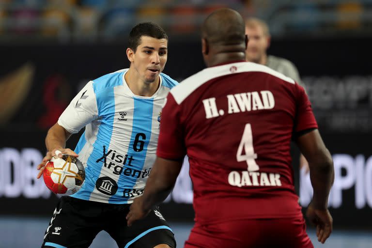 El defensa central argentino Diego Simonet (izq.) Es cerrado por el pivote de Qatar Hassan Mabrouk (der.) Durante el partido del Campeonato Mundial Masculino de Balonmano 2021 entre los equipos del Grupo II Argentina y Qatar en el estadio de deportes de El Cairo en la capital egipcia el 25 de enero 