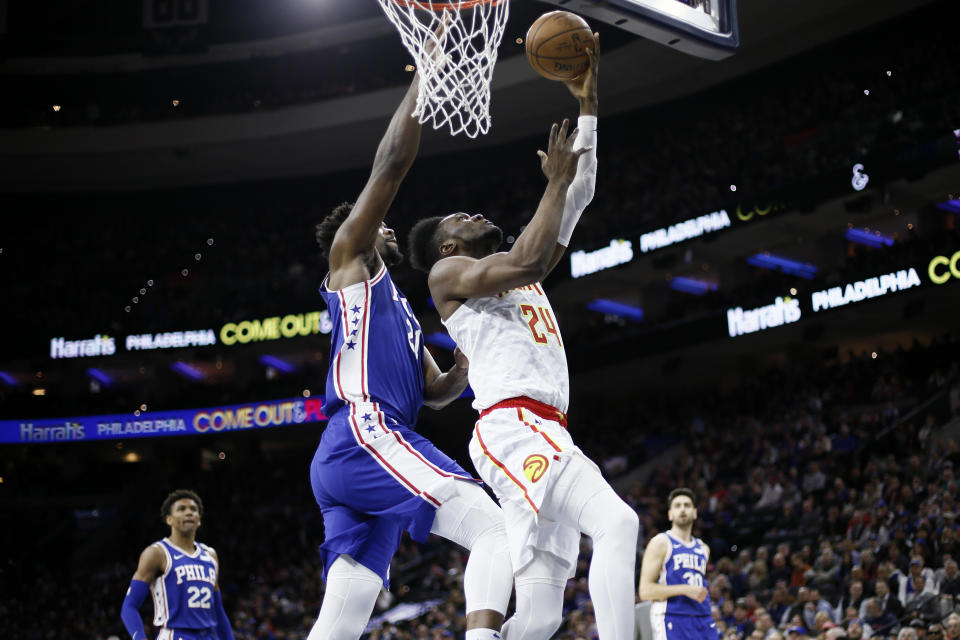 Atlanta Hawks' Bruno Fernando (24) goes up to shoot against Philadelphia 76ers' Joel Embiid (21) during the first half of an NBA basketball game, Monday, Feb. 24, 2020, in Philadelphia. (AP Photo/Matt Slocum)