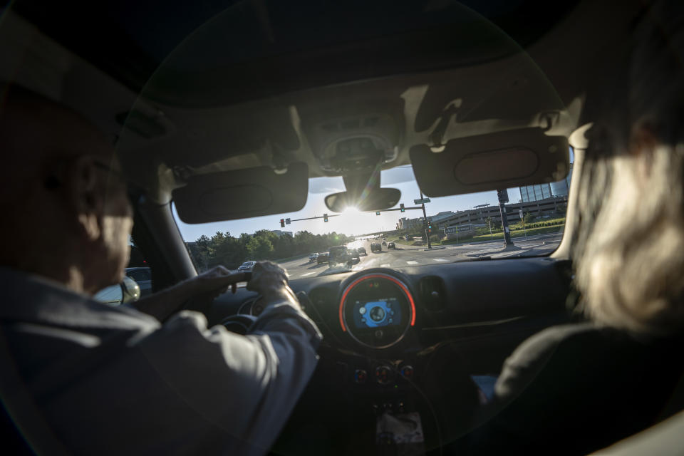 Lonnie Phillips, left, and his wife, Sandy, drive to visit the memorial honoring the victims of the 2012 mass shooting at an Aurora, Colo., movie theater, including Sandy’s daughter, Jessica Ghawi, as the sun rises in Lone Tree, Colo., Tuesday, Sept. 5, 2023. Suffering through their own personal loss, the couple set out to help other parents like them, traveling to shooting sites around the country. The trip continued for a decade. (AP Photo/David Goldman)