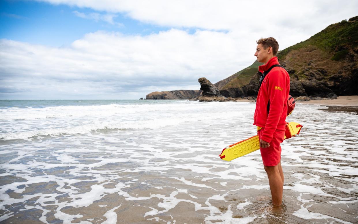 Portrait of RNLI lifeguard Hugo Rattenbury at Llangrannog beach, Wales.