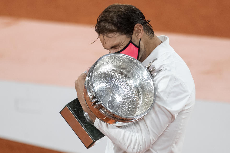 Rafael Nadal reacts as he embraces the trophy after his victory against Novak Djokovic in the Singles Final on Court Philippe-Chatrier during the French Open.