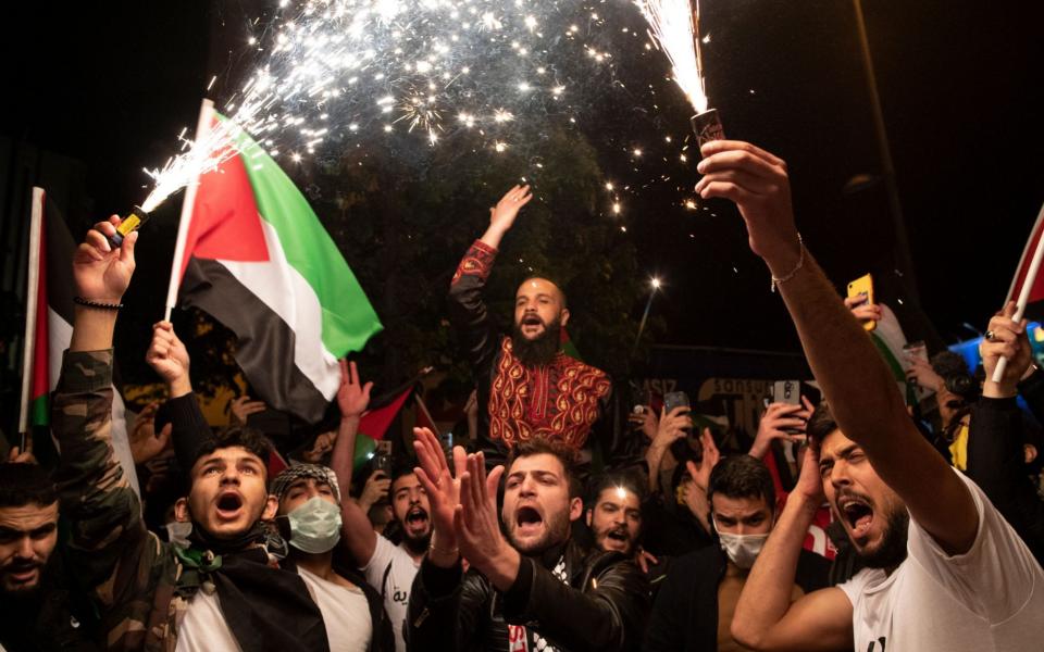 Protestors hold Palestinian flags and shout slogans against Israel during a demonstration in front of Israel Consulate in Istanbul