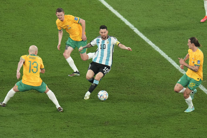 Argentina's Lionel Messi, center, controls the ball surrounded by Australia's Aaron Mooy, left and his teammates Kye Rowles and Jackson Irvine during the World Cup round of 16 soccer match between Argentina and Australia at the Ahmad Bin Ali Stadium in Doha, Qatar, Saturday, Dec. 3, 2022. (AP Photo/Alessandra Tarantino)