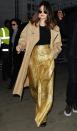 Selena Gomez shines in gold, high-waisted pants and a black top in London on Wednesday. 
