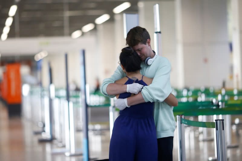 Paul Michael, an American Citizen hugs his Brazilian friend Barbara Costa before boarding at Brazilian International Airport amid the coronavirus disease (COVID-19) outbreak in Brasilia