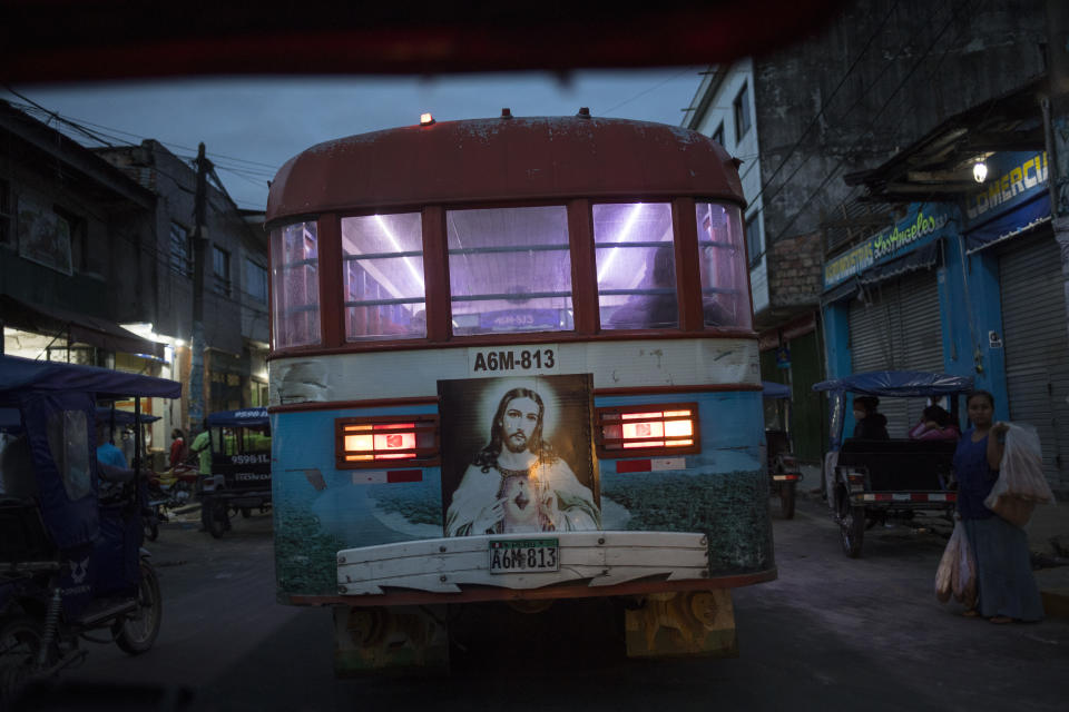 A Sacred Heart of Jesus Christ image decorates the back of a public bus in Iquitos, Peru, early Saturday, March 20, 2021. Almost a year ago, dozens of victims were clandestinely buried in Iquitos, a city in Loreto state in the heart of the Peruvian Amazon. Local authorities approved the burials but never told the families, who believed their loved ones were in a local cemetery — and only a couple of months later they found out the truth. (AP Photo/Rodrigo Abd)