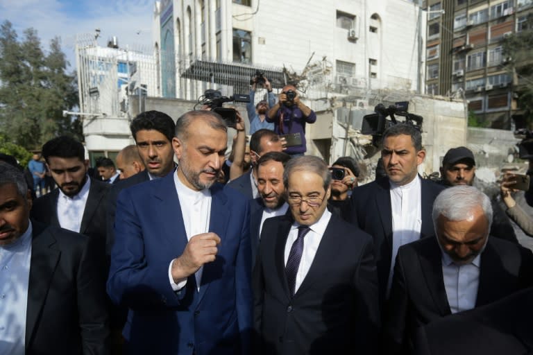 El ministro iraní de Exteriores, Hossein Amir-Abdollahian (izq.), dialoga con su homólogo sirio, Faisal Mekdad, junto al embajador de Irán en Siria, Hossein Akbari (c), durante su visita al bombardeado consulado en Damasco el 8 de abril de 2024 (Louai Beshara)