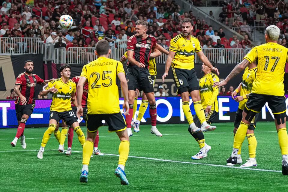 Jul 20, 2024; Atlanta, Georgia, USA; Atlanta United defender Stian Gregersen (5) heads in a goal behind Columbus Crew defender Rudy Camacho (4) during the second half at Mercedes-Benz Stadium. Mandatory Credit: Dale Zanine-USA TODAY Sports