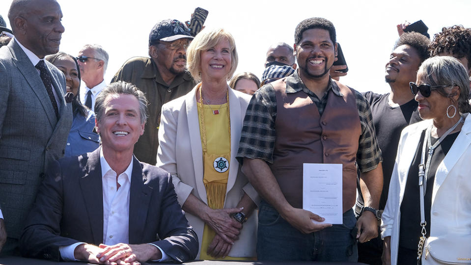 Anthony Bruce holds a bill "Bruce's Beach Bill" after California Gov. Gavin Newsom signed it, Thursday, Sept. 30, 2021, in Manhattan Beach, Calif.