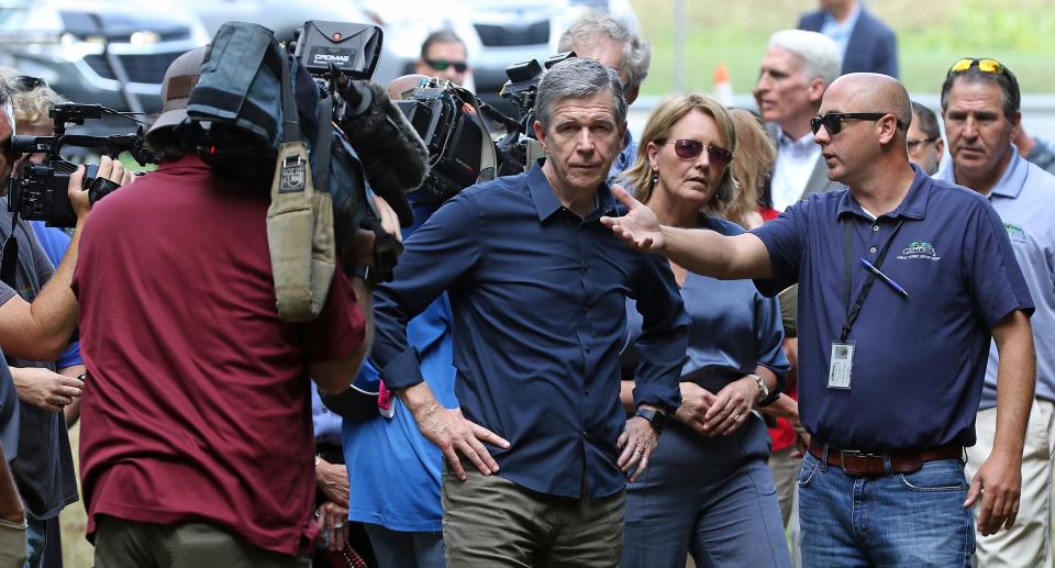 North Carolina Gov. Roy Cooper talks with Robert Cloninger with Gastonia Public Works Friday morning, Aug. 12, 2022, during a Nationwide Climate Resilience Funding announcement held at Duharts Creek on East Franklin Boulevard.