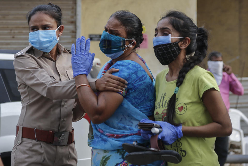 Relatives of a patient who died of COVID-19, mourn outside a government COVID-19 hospital in Ahmedabad, India, Tuesday, April 27, 2021. The COVID-19 death toll in India has topped 200,000 as the country endures its darkest chapter of the pandemic yet. (AP Photo/Ajit Solanki)