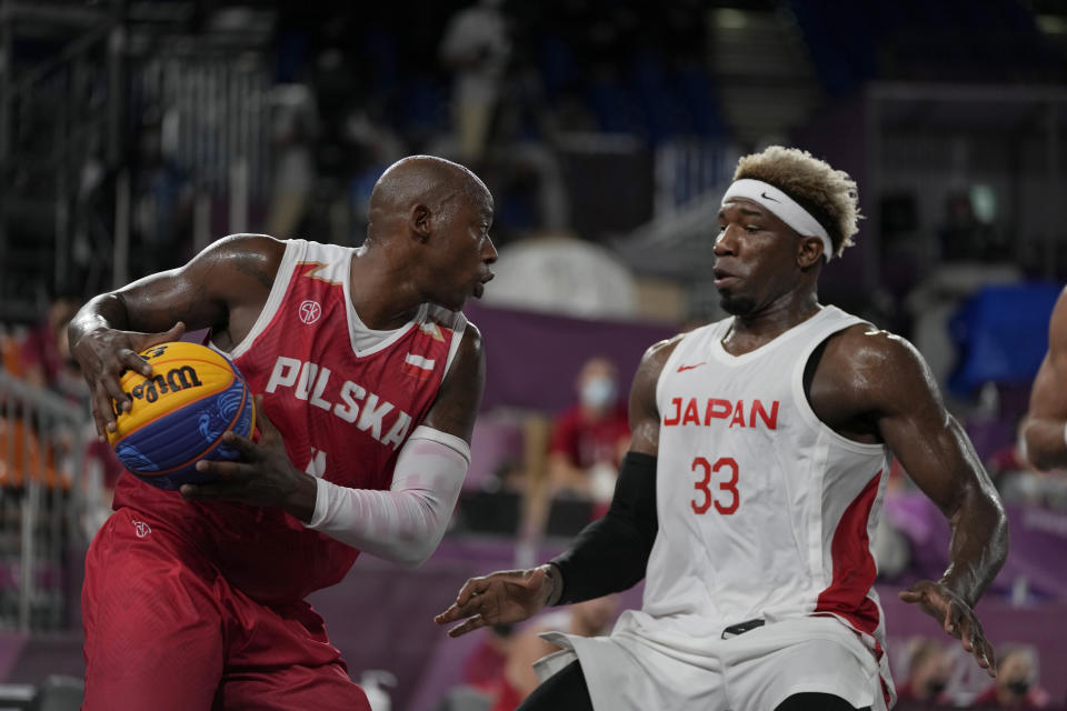 Poland's Michael Hicks, left, looks to pass around Japan's Ira Brown (33) during a men's 3-on-3 basketball game at the 2020 Summer Olympics, Saturday, July 24, 2021, in Tokyo, Japan. (AP Photo/Jeff Roberson)