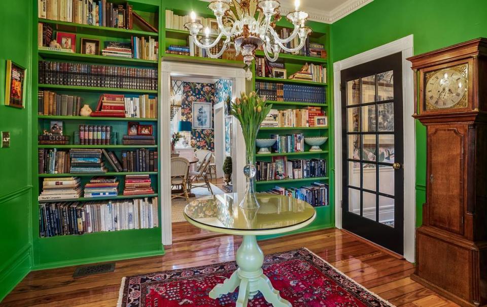 This home library is on of the few areas in the home that doesn’t feature wallpaper. It’s green with built-in shelving.