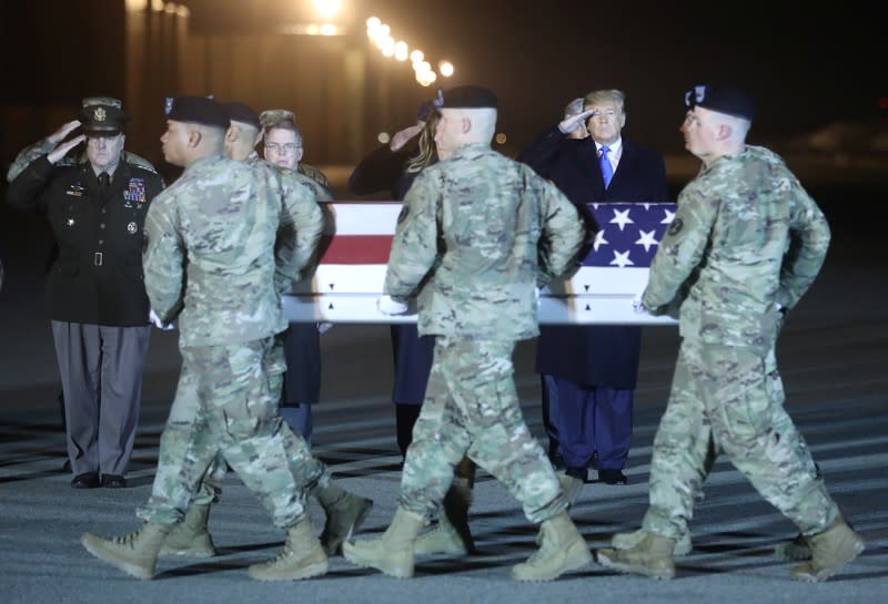 U.S. President Donald Trump salutes during a dignified transfer at Dover Air Force Base