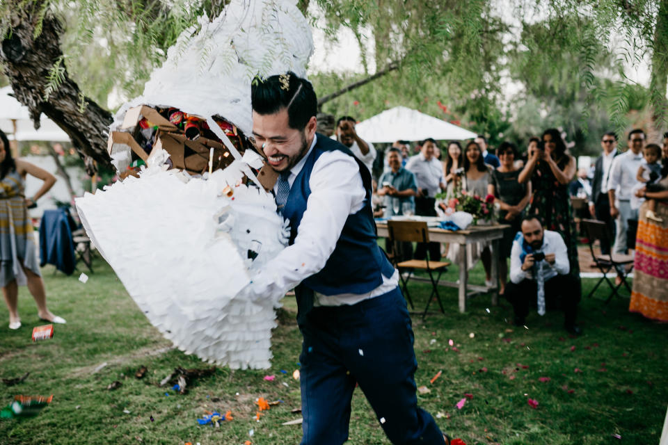 The groom ended up tackling the pi&ntilde;ata to get all the goodies out.&nbsp; (Photo: <a href="http://lukeandmallory.com/" target="_blank">Luke and Mallory</a>)