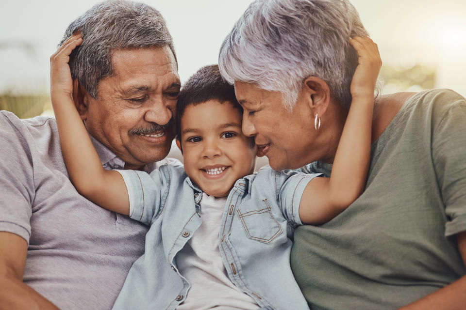 Grandparents share a joyful moment with their grandson, hugging and smiling together