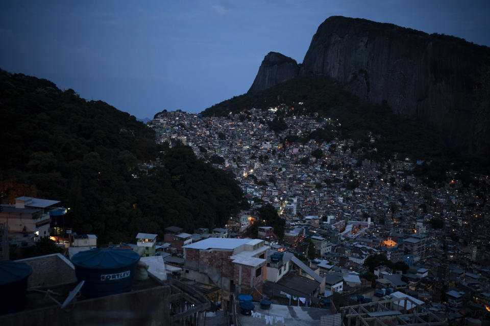 Homes are illuminated at dusk in the Rocinha slum of Rio de Janeiro, Brazil, Thursday, March 18, 2021. Gangs control many of Rio’s hundreds of favelas like Rocinha that are home to 1.7 million people, or about 14% of the metropolitan region's population, according to the 2010 census. Services are usually precarious and chances for social advancement limited. (AP Photo/Felipe Dana)