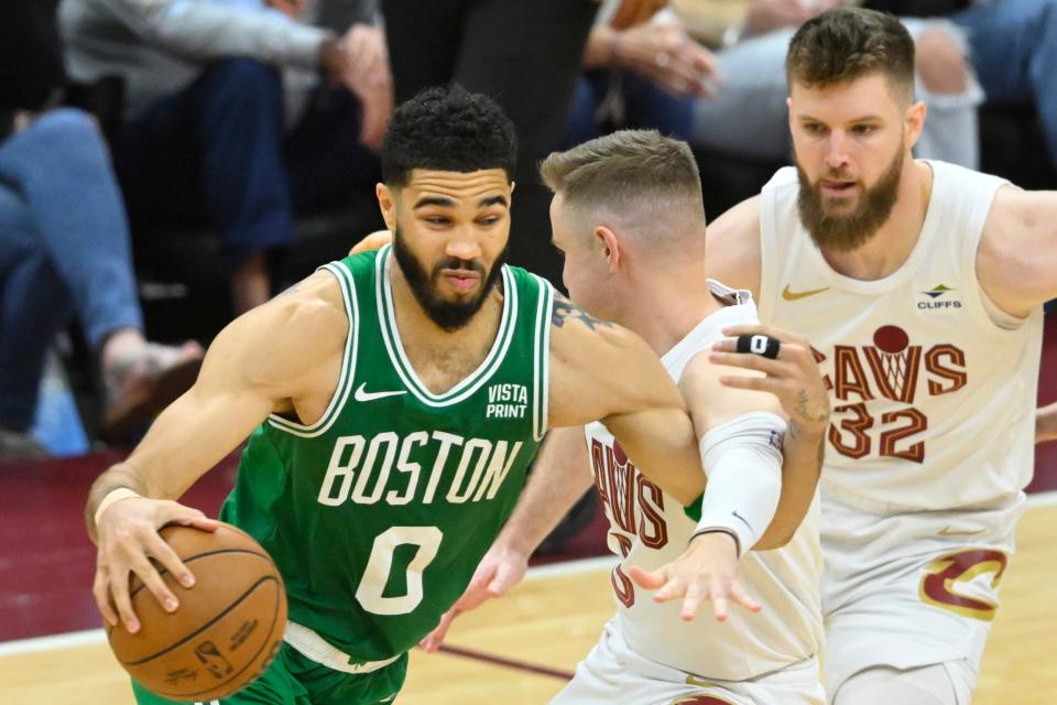 Celtics forward Jayson Tatum drives against Cavs guard Sam Merrill and forward Dean Wade during Game 4 in Cleveland.