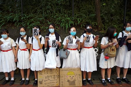 Secondary school students shout slogans as they form a human chain in Hong Kong