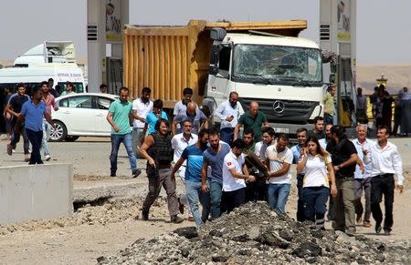 People carry a body away from the blast scene where two officers and one civilian were killed when a car bomb exploded outside a police station near the southeastern city of Diyarbakir, Turkey August 15, 2016. REUTERS/Ihlas News Agency via REUTERS