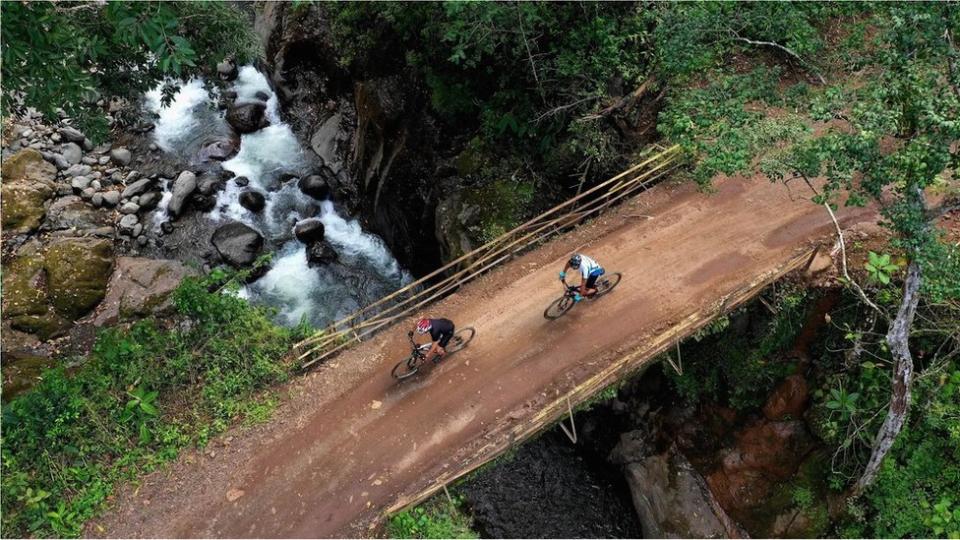 兩名騎單車的人經過一座橋樑