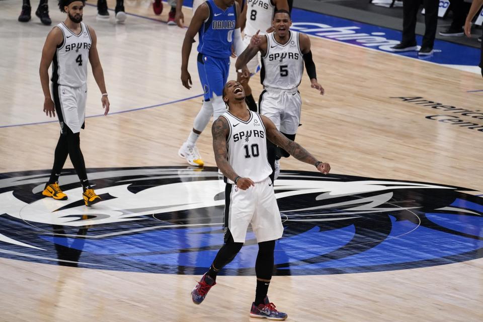 San Antonio Spurs forward DeMar DeRozan, celebrates after sinking a basket in the final second of the second half of an NBA basketball game against the Dallas Mavericks in Dallas, Sunday, April 11, 2021. Spurs' Derrick White (4) and Dejounte Murray (5) look on as DeRozan celebrates. (AP Photo/Tony Gutierrez)