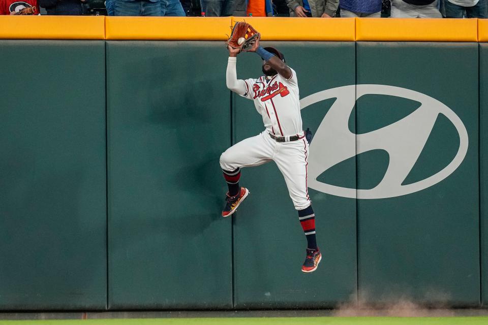 Braves center fielder Michael Harris catches a fly ball at the wall against the Mets.
