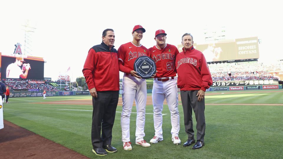 Ohtani receives his 2021 American League MVP trophy alongside his teammate and three-time MVP outfielder Mike Trout. - Kyodo News/Getty Images