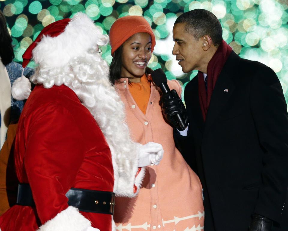President Barack Obama, right, and daughter Malia Obama, sing as Santa Claus arrives during the 90th annual National Christmas Tree Lighting ceremony on the Ellipse south of the White House, Thursday, Dec. 6, 2012, in Washington. (AP Photo/Alex Brandon)