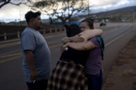 Nora Bulosan, a la derecha, y Hannah Tomas, residentes de Lahaina que sobrevivieron a un incendio que devastó al poblado, se consuelan mutuamente tras reunirse con la esperanza de poder acceder a sus casas, el miércoles 16 de agosto de 2023, en Lahaina, Hawai. (AP Foto/Jae C. Hong)