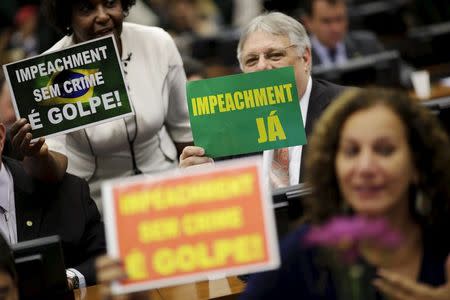 Congressmen hold signs during a session of the impeachment committee of Brazil's President Dilma Rousseff, in Brasilia, Brazil, April11, 2016. REUTERS/Ueslei Marcelino