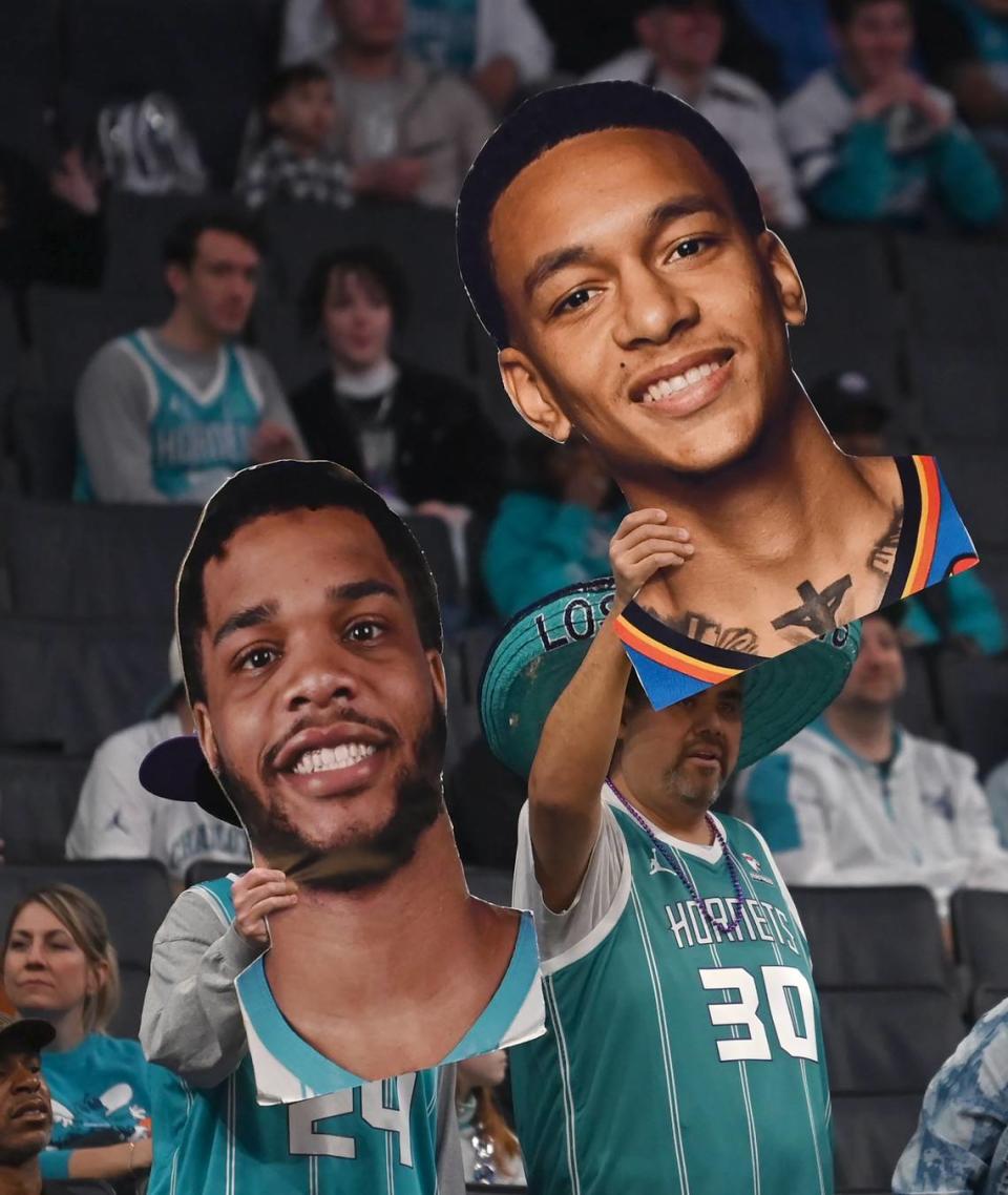 Charlotte Hornets fans hold up fat heads of Hornets forward forward Miles Bridges, left and guard Tre Mann, right, during the team’s game against the Indiana Pacers at Spectrum Center in Charlotte, NC on Monday, February 12, 2024.