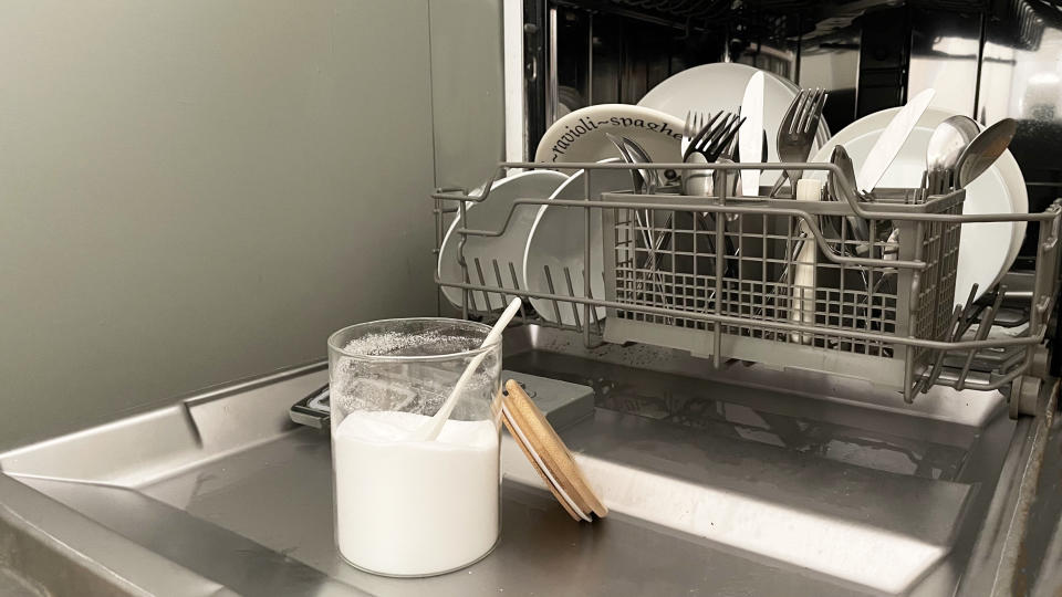 baking soda sitting on the open door of a dishwasher